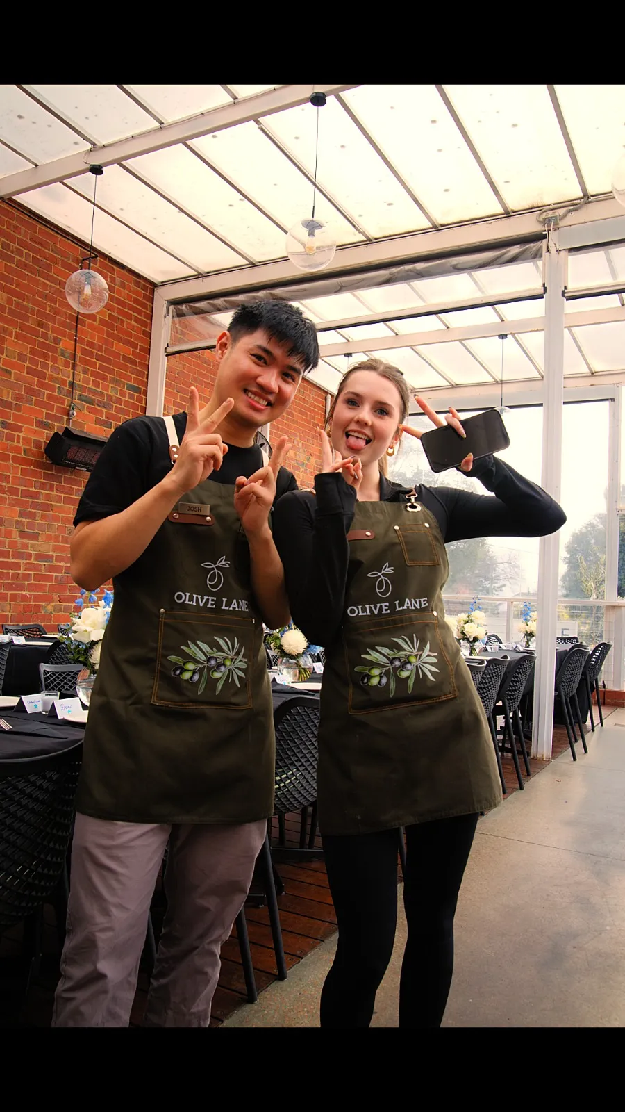 Olive Lane team members celebrating together in branded aprons at a private event
